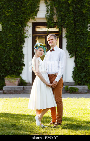 Young wedding couple enjoying romantic moments outside on a summer meadow Stock Photo