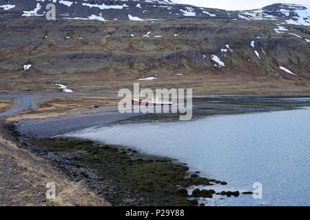 Abandoned and beached fishing boat in bay in Iceland Stock Photo