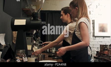 Two young female barista working in coffee shop, pareparing coffee Stock Photo