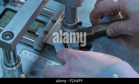 Craftsman working on frame, glue together pieces in special machine Stock Photo