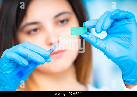 technician girl with microfluidic device LOC in microbiological lab Stock Photo