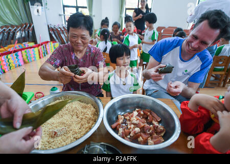 Changxing, China's Zhejiang Province. 14th June, 2018. Villagers and foreigners make zongzi, a pyramid-shaped dumpling made of glutinous rice wrapped in bamboo or reed leaves, to greet the upcoming Dragon Boat Festival in Changxing County, east China's Zhejiang Province, June 14, 2018. Credit: Xu Yu/Xinhua/Alamy Live News Stock Photo