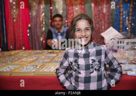 Manchester, UK. 14th June 2018. A young girl stood in front of her Fathers store as Muslims celebrate Chaand Raat, which translated literally means night of the moon.  The festival marks the end of Ramadam and the night before Eid. (consent given) Longsight Market, Manchester, 14th June, 2018 (C)Barbara Cook/Alamy Live News Stock Photo