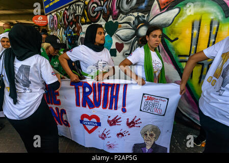 London, UK. 14th June 2018. Grenfell Youth carry their banner under the Westway before thousands walk in silence from close to Grenfell Tower remembering the victims of the disaster on the first anniversary of the disastrous fire which killed 72 and left survivors traumatised. Many of those made homeless by the fire are still in temporary accomodation a year later despite promises mde by Theresa May and Kensington & Chelsea council, who many fell have failed the local community both before and after the fire. Credit: Peter Marshall/Alamy Live News Stock Photo