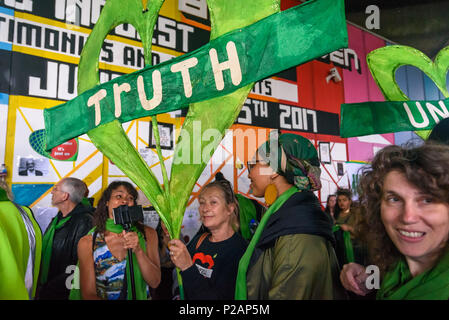 London, UK. 14th June 2018. People hold large Grenfell hearts under the Westway as they wait to walk with thousands in silence from close to Grenfell Tower remembering the victims of the disaster on the first anniversary of the disastrous fire which killed 72 and left survivors traumatised. Many of those made homeless by the fire are still in temporary accomodation a year later despite promises mde by Theresa May and Kensington & Chelsea council, who many fell have failed the local community both before and after the fire. They say had they been listened to and respected Grenfell would not hav Stock Photo