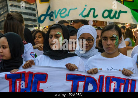 London, UK. 14th June 2018. Young women hold the Grenfell Youth banner as they line up with thousands to walk in silence from close to Grenfell Tower remembering the victims of the disaster on the first anniversary of the disastrous fire which killed 72 and left survivors traumatised. Many of those made homeless by the fire are still in temporary accomodation a year later despite promises mde by Theresa May and Kensington & Chelsea council, who many fell have failed the local community both before and after the fire. They say had they been listened to and respected Grenfell would not have happ Stock Photo