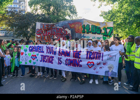 London, UK. 14th June 2018. Grenfell Youth and others line up to walk with their banner with thousands of people in silence from close to Grenfell Tower remembering the victims of the disaster on the first anniversary of the disastrous fire which killed 72 and left survivors traumatised. Many of those made homeless by the fire are still in temporary accomodation a year later despite promises mde by Theresa May and Kensington & Chelsea council, who many fell have failed the local community both before and after the fire. They say had they been listened to and respected Grenfell would not have h Stock Photo