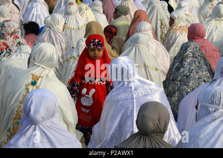 Susoh, Aceh, Indonesia. 15th June, 2018. A little girl wearing red clothes seen surrounded by women praying during Eid al-Fitr. After practicing Ramadan, muslims around the worlds celebrate the big day of Islam knows as Eid al-Fitr. Indonesia is the country with the largest Muslim majority in the world, where millions of Muslims celebrate Eid al-Fitr every year. Credit: Mimi Saputra/SOPA Images/ZUMA Wire/Alamy Live News Stock Photo