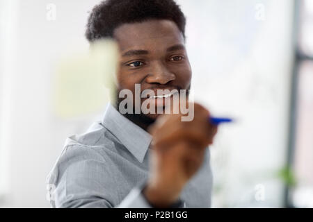 businessman writing on glass board at office Stock Photo