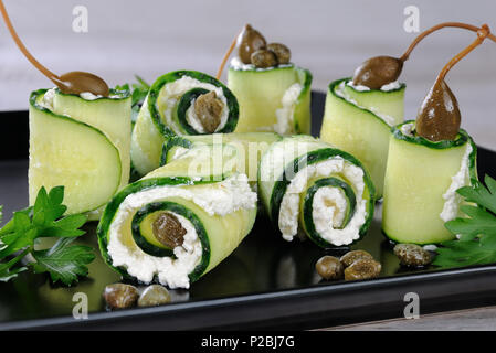 Cucumber rolls with ricotta filling and capers.   These rolls with the size of a bite -is a great option with a low fat content, which serves as a sna Stock Photo