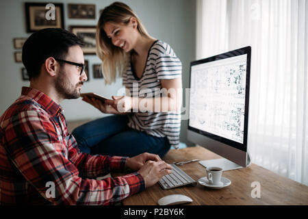 Young attractive designers working on project together Stock Photo