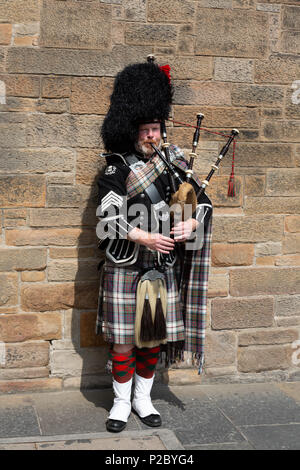 Full length image of Scotsman in his 40s dressed in tartan and kilt playing the bagpipes, Edinburgh, Scotland UK Stock Photo