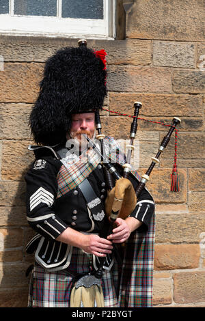 Scotsman in his 40s dressed in tartan and kilt playing the bagpipes, Edinburgh, Scotland UK Stock Photo