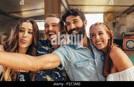 Happy young guy with friends taking a selfie. Group of friends making selfie at outdoors. Stock Photo