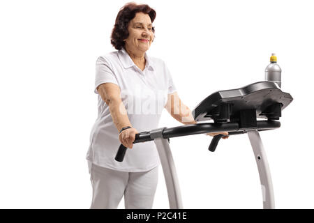 Mature woman exercising on a treadmill isolated on white background Stock Photo