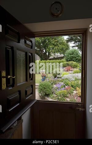 View of a country garden seen through a stable style door Stock Photo