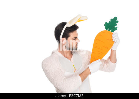 Man wearing rabbit costume and holding carrot isolated on white, easter concept Stock Photo