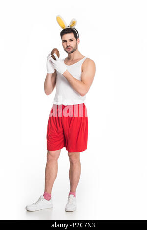 Man with bunny ears holding chocolate egg isolated on white, easter concept Stock Photo