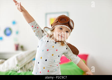 happy little girl in pilot hat playing at home Stock Photo