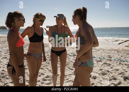 Female volleyball coach interacting with female players Stock Photo