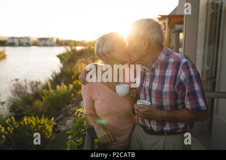 Senior couple kissing each other in the balcony Stock Photo