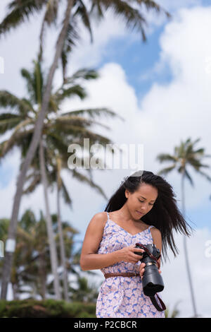 Woman reviewing pictures on digital camera in the beach Stock Photo