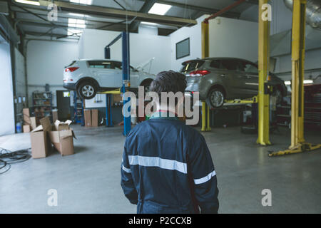 Mechanic standing in repair garage Stock Photo