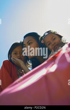 Malay mother and her two young daughters wearing traditional Baju Kurung dresses smiling happily into camera during Hari Raya celebration Stock Photo Alamy