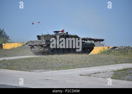 An Austrian Leopard 2A4 tank, operated by Austrian soldiers assigned to 6th Tank Company, 14th Panzer Battalion, fires at its target during the Strong Europe Tank Challenge (SETC), at the 7th Army Training Command's Grafenwoehr Training Area, Grafenwoehr, Germany, June 04, 2018, June 4, 2018. U.S. Army Europe and the German Army co-host the third Strong Europe Tank Challenge at Grafenwoehr Training Area, June 3 - 8, 2018. The Strong Europe Tank Challenge is an annual training event designed to give participating nations a dynamic, productive and fun environment in which to foster military part Stock Photo