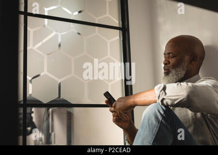 Senior graphic designer using mobile phone Stock Photo