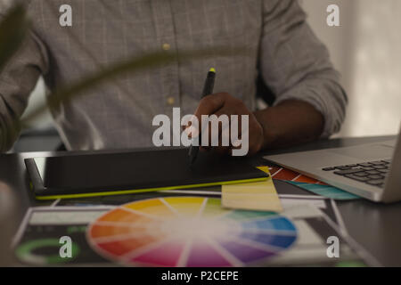 Senior graphic designer using graphics tablet in office Stock Photo