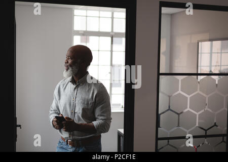 Senior graphic designer using mobile phone Stock Photo