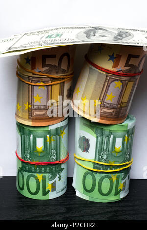 Rolled several thousand euro, dollars banknotes with rubbers background. Euro Currency, Rolled banknote on white background. Stock Photo