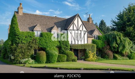 Large house covered by foliage in the village of Tredington, Warwickshire, England. Panoramic Stock Photo
