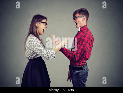 Side view of young man and woman accusing each other and screaming having problems. Stock Photo