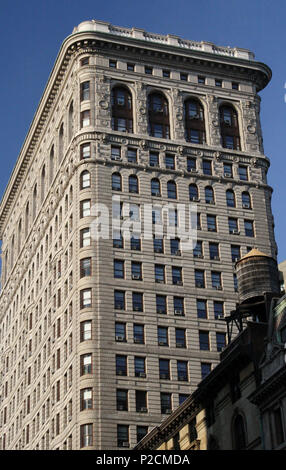 . English: The Flatiron Building (or Fuller Building, as it was originally called) is located at 175 Fifth Avenue in the borough of Manhattan, New York City and is considered to be a groundbreaking skyscraper. Upon completion in 1902, it was one of the tallest buildings in the city and the only skyscraper north of 14th Street. The building sits on a triangular island-block formed by Fifth Avenue, Broadway and East 22nd Street, with 23rd Street grazing the triangle's northern (uptown) peak. As with numerous other wedge-shaped buildings, the name 'Flatiron' derives from its resemblance to a cast Stock Photo