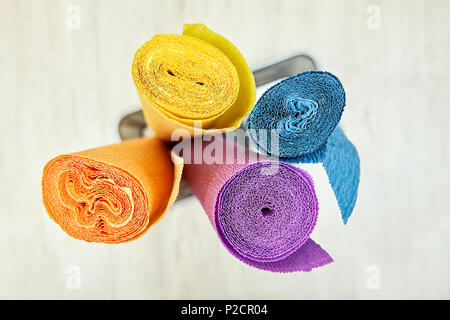 Corrugated wrapping paper is twisted into four colored rolls. Stock Photo