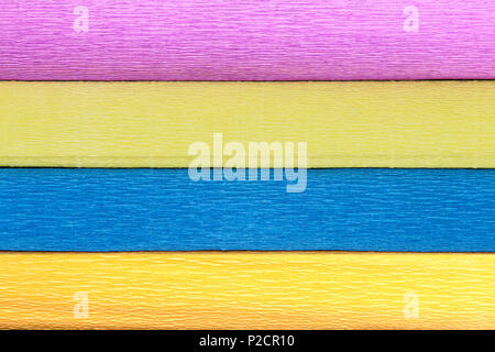 Texture of four different-colored rolls of wrinkled paper. Stock Photo
