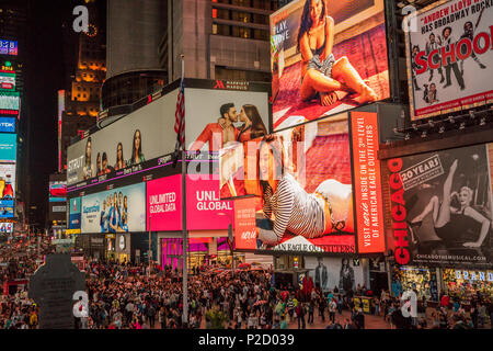 Crowds gather to see the spectacle of Times Square at night with the illuminated and animated advertising screens in Manhattan, New York city Stock Photo