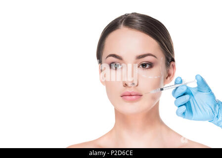 beautiful young woman with dotted line drawn on face for plastic surgery taking beauty injection isolated on white Stock Photo