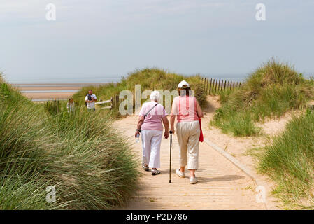 two senior ladies walking on a footpath at fomby beach near liverpool, england, britain, uk, Stock Photo