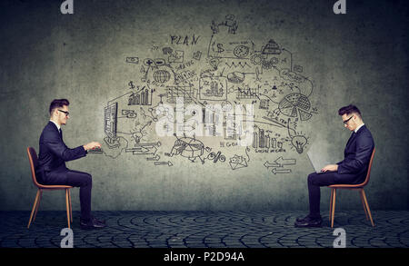 Side view of men sitting on chairs and using computer creating business plan in virtual reality on gray background Stock Photo