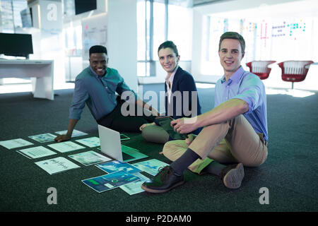 Portrait of male and female executives discussing over graph Stock Photo