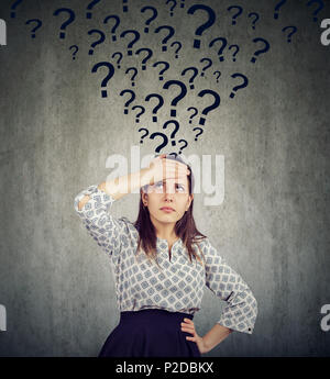 Young thoughtful woman with too many questions thinking hard Stock Photo