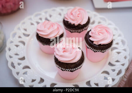 Tasty pink decoration cupcakes on stand close-up Stock Photo