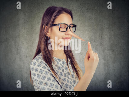 Sly tricky young woman with long nose. Liar concept. Stock Photo