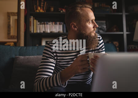 Thoughtful man looking away while having coffee Stock Photo