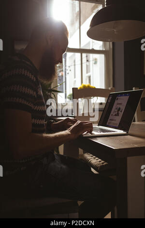 Man sitting on chair using his laptop Stock Photo
