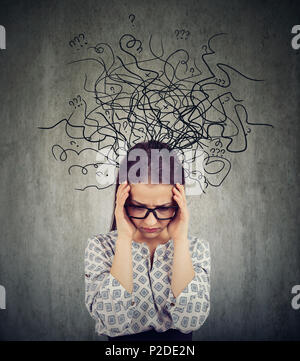 Girl in glasses having problems with mental health and looking deep in chaos on gray background Stock Photo