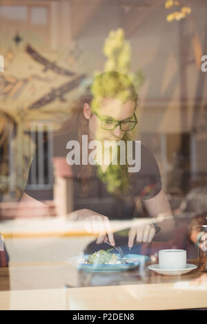 Woman having breakfast and coffee at table Stock Photo